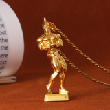 Gold-colored trophy figure on a chain against a brown background